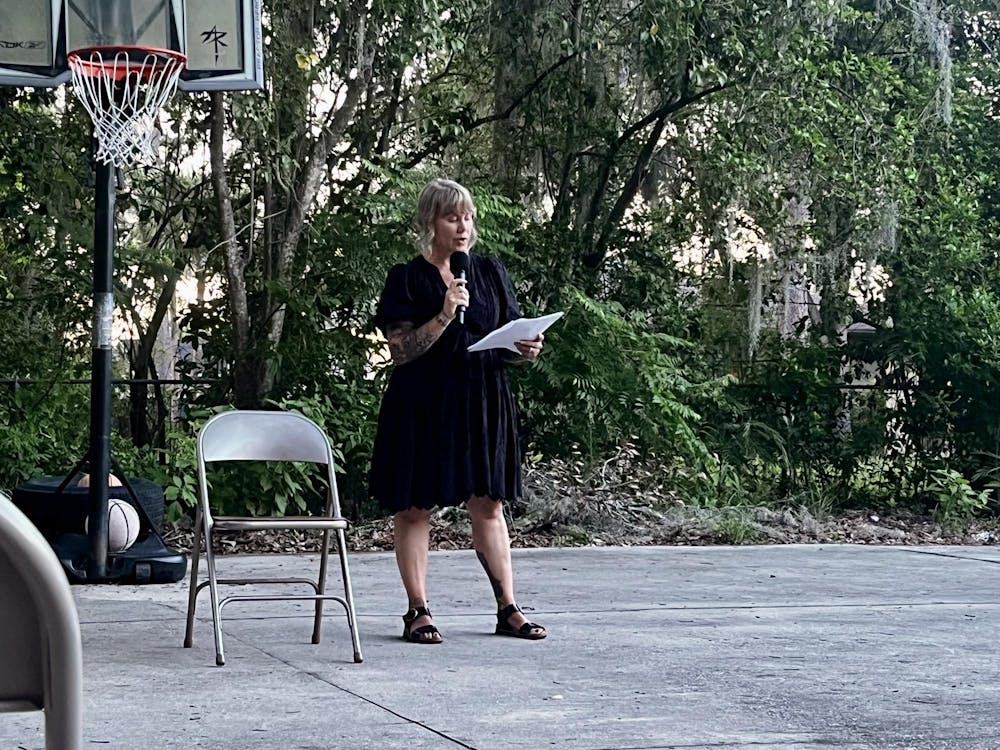 Emily Westerholm, the founder and executive director of Released Reentry, recites a poem at an Open Mic Poetry Nights event at Released Reentry in Gainesville, Fla., on June 10, 2026. 