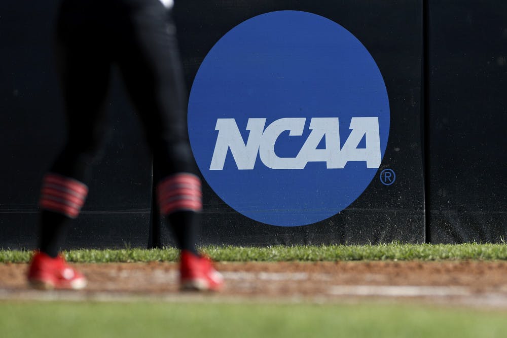 <p>FILE - In this April 19, 2019, file photo, an athlete stands near a NCAA logo during a softball game in Beaumont, Texas. The NCAA is poised to take a significant step toward allowing college athletes to earn money without violating amateurism rules. The Board of Governors will be briefed Tuesday, Oct. 29 by administrators who have been examining whether it would be feasible to allow college athletes to profit of their names, images and likenesses. A California law set to take effect in 2023 would make it illegal for NCAA schools in the state to prevent athletes from signing personal endorsement deals. (AP Photo/Aaron M. Sprecher, File)</p>