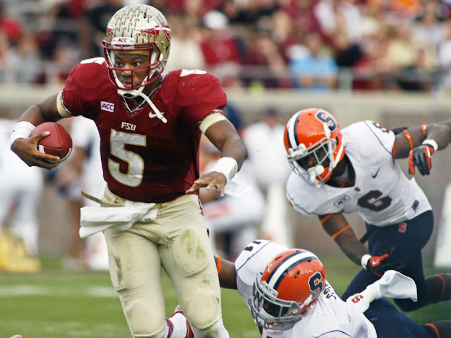 Florida State quarterback Jameis Winston (5) escapes a sack attempt by Syracuse linebacker Marquis Spruill (11) during the Seminoles’ 59-3 victory against the Orange on Nov. 16 in Tallahassee.