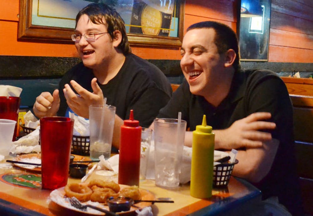 <p class="p1"><span class="s1">UF telecommunication freshman Matthew Szlasa, 19, and accounting graduate student Jacob Sperber, 23, eat wings and share some laughs at Gator City on Tuesday evening.</span></p>
