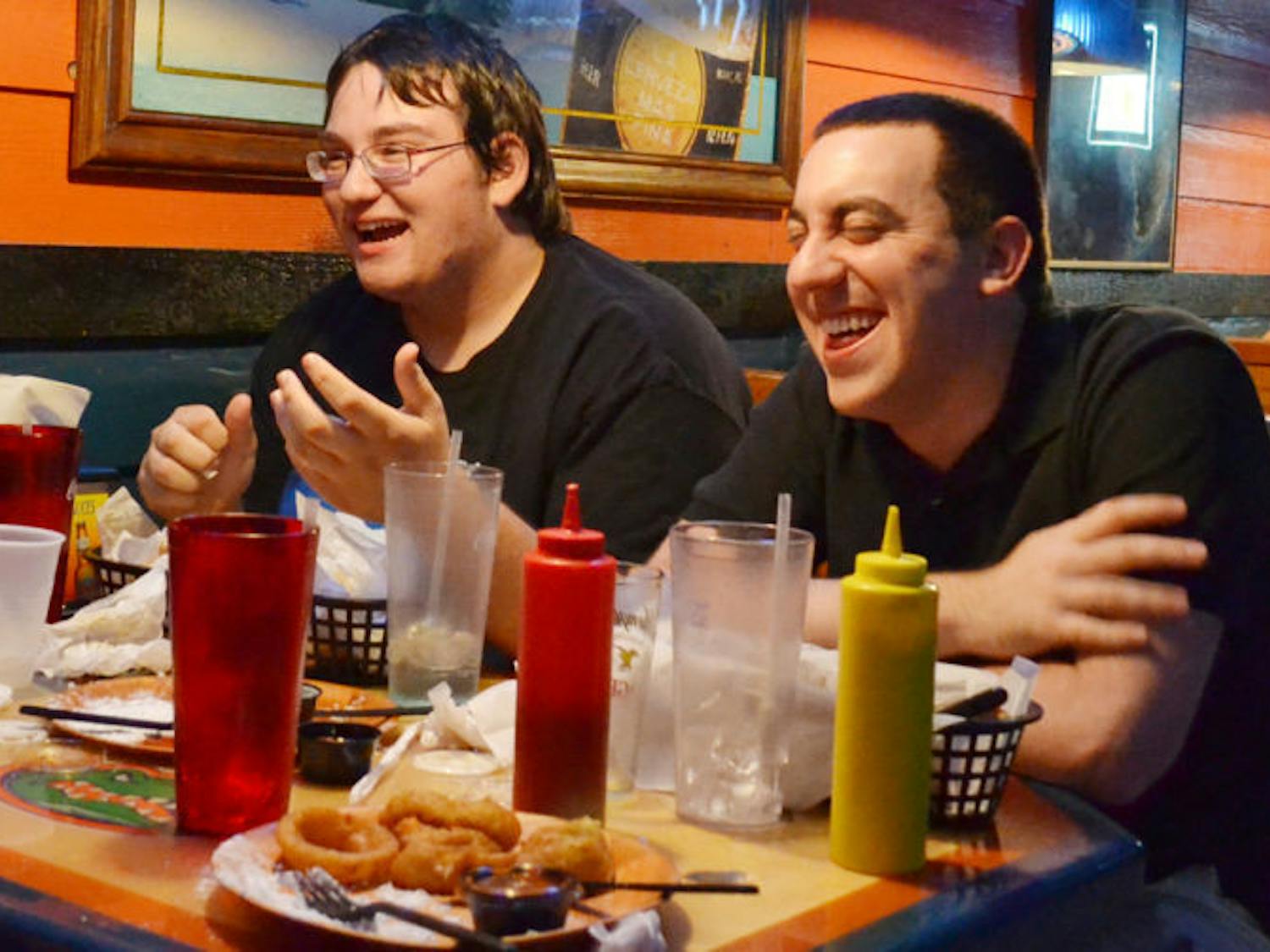 UF telecommunication freshman Matthew Szlasa, 19, and accounting graduate student Jacob Sperber, 23, eat wings and share some laughs at Gator City on Tuesday evening.