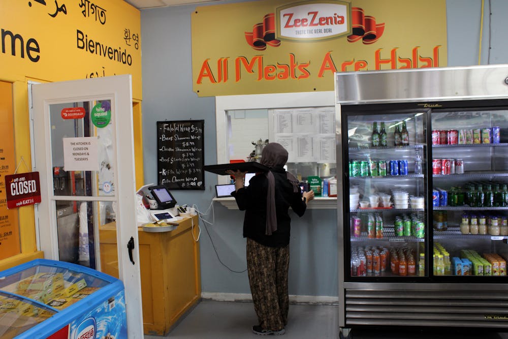 <p>A worker at Zeezenia International Market delivers Mediterranean food to a customer on Friday, Feb. 11.</p>