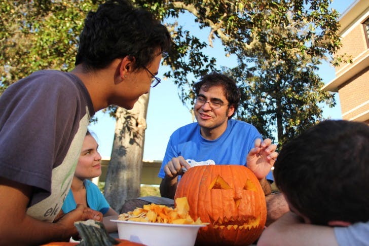 Michael Gonzalez, 20, shares his enthusiasm for carving pumpkins with his friends Ruben Quesada, 20, far left; Michelle Altemus, 20, left; and Marcus Lewis, 19, right; on Sunday afternoon.