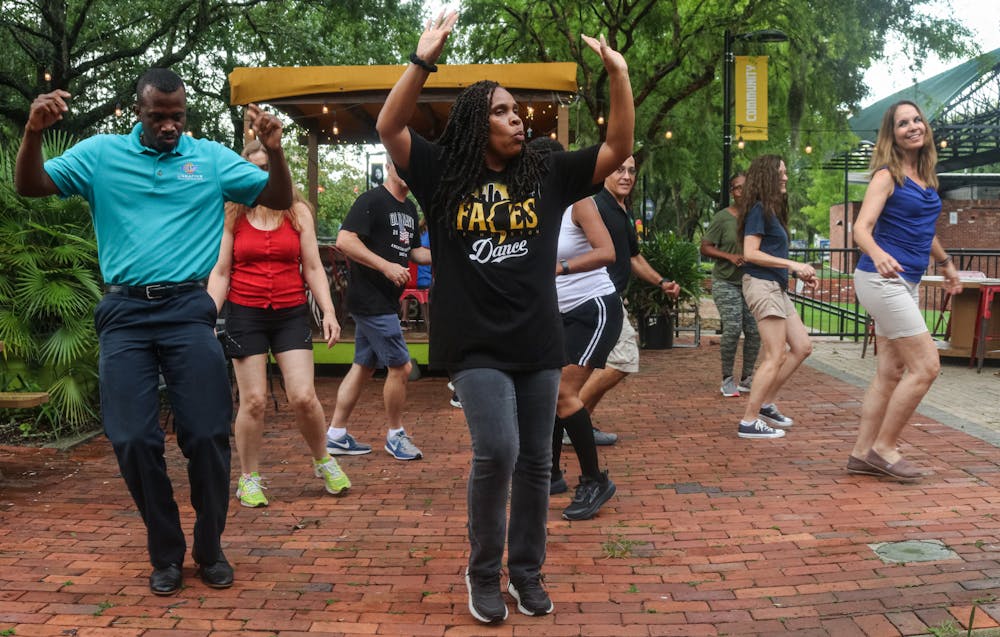 Wanda Lloyd, 47 (center), teaches students line dancing outside Muñecas Downtown Taco Garden after rain forced the class to avoid the slippery surfaces at the Bo Diddley Plaza amphitheater on Tuesday, June 22, 2021.