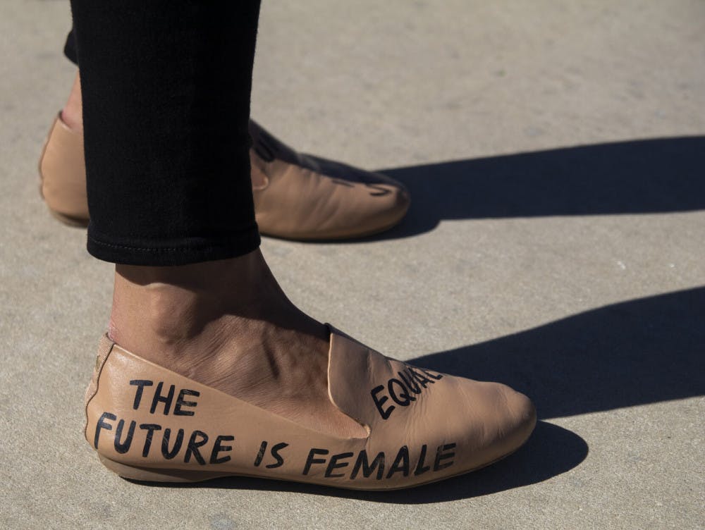A campaign staffer wears flats stating “The future is female” and “equality” during the “Good Trouble” rally held at Depot Park on Saturday, Oct. 31, 2020.&nbsp;