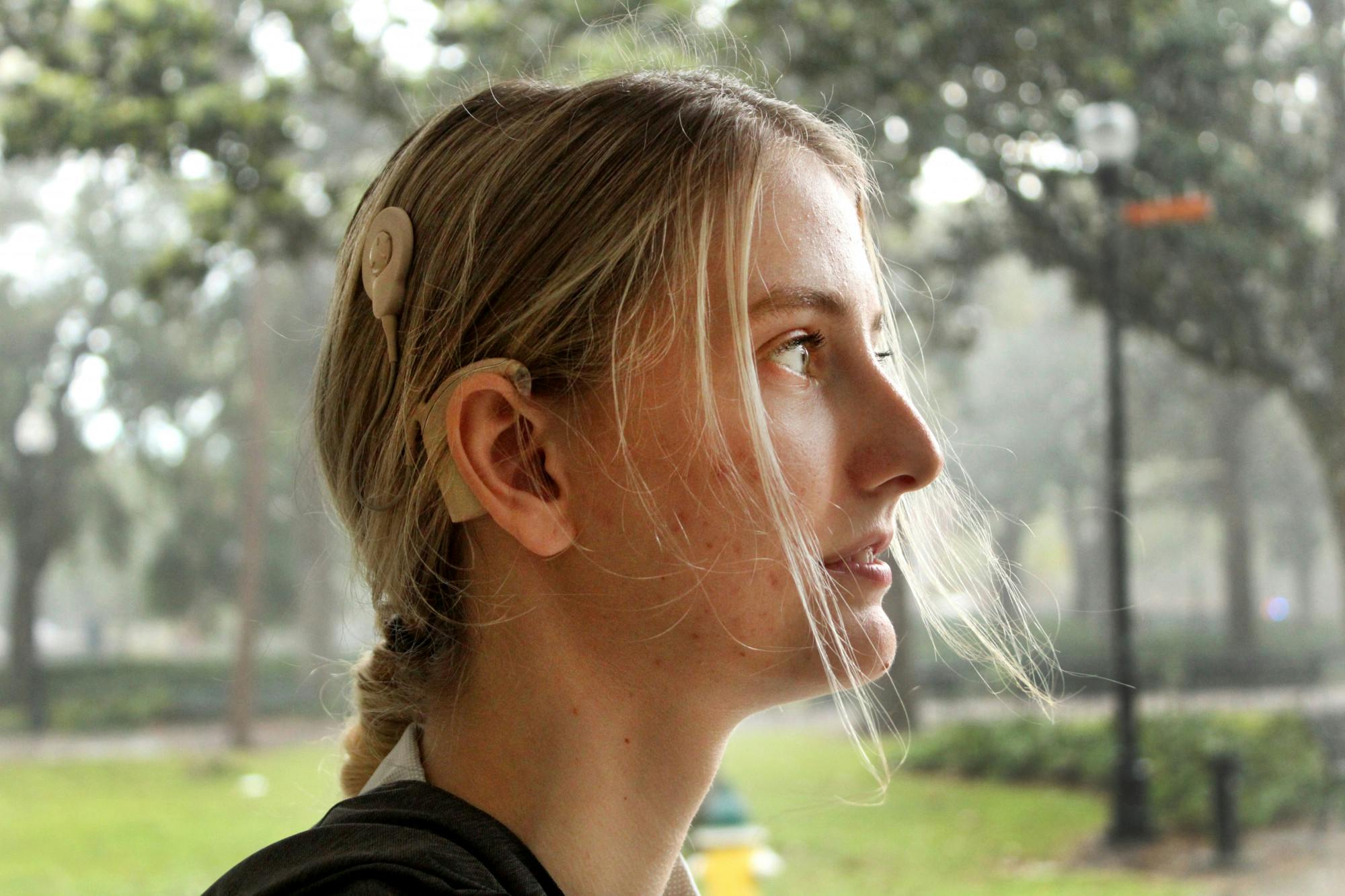 Paige Fultz, 20, nursing student at Santa Fe College, poses for a portrait in Plaza of the Americas on Sunday, April 17. Fultz, who is deaf, wears a cochlear implant.