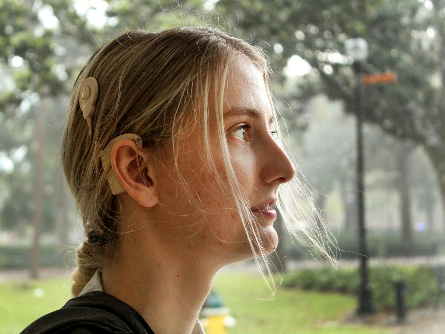 Paige Fultz, 20, nursing student at Santa Fe College, poses for a portrait in Plaza of the Americas on Sunday, April 17. Fultz, who is deaf, wears a cochlear implant.