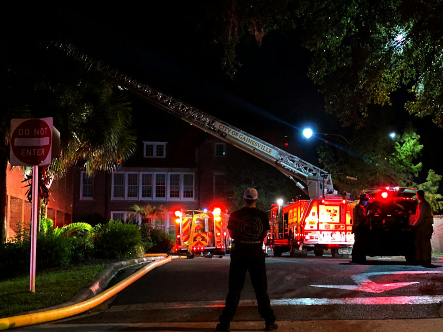 An emergency responder looks on at the scene of a fire at Norman Hall Monday night.