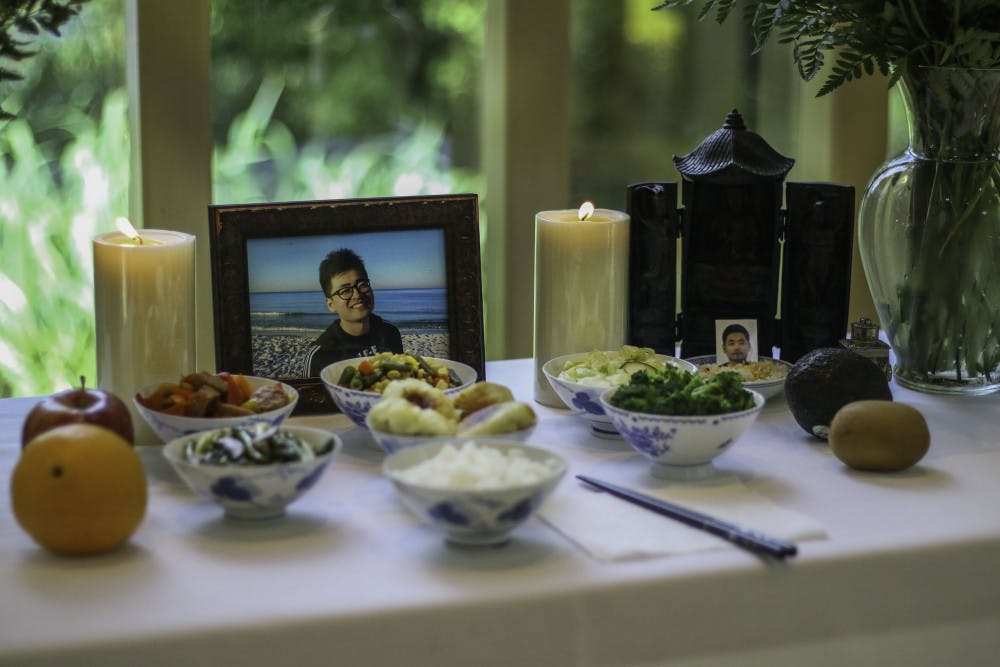 A memorial for Huixiang Chen, a University of Florida international doctoral candidate who died by suicide June 13, was made up of photos of Chen, candles and a variety of dishes Wednesday at the front of the Baughman Center during a celebration of life service. There was standing room only in the chapel as over 150 people gathered to remember Chen and pay respects to the family.
