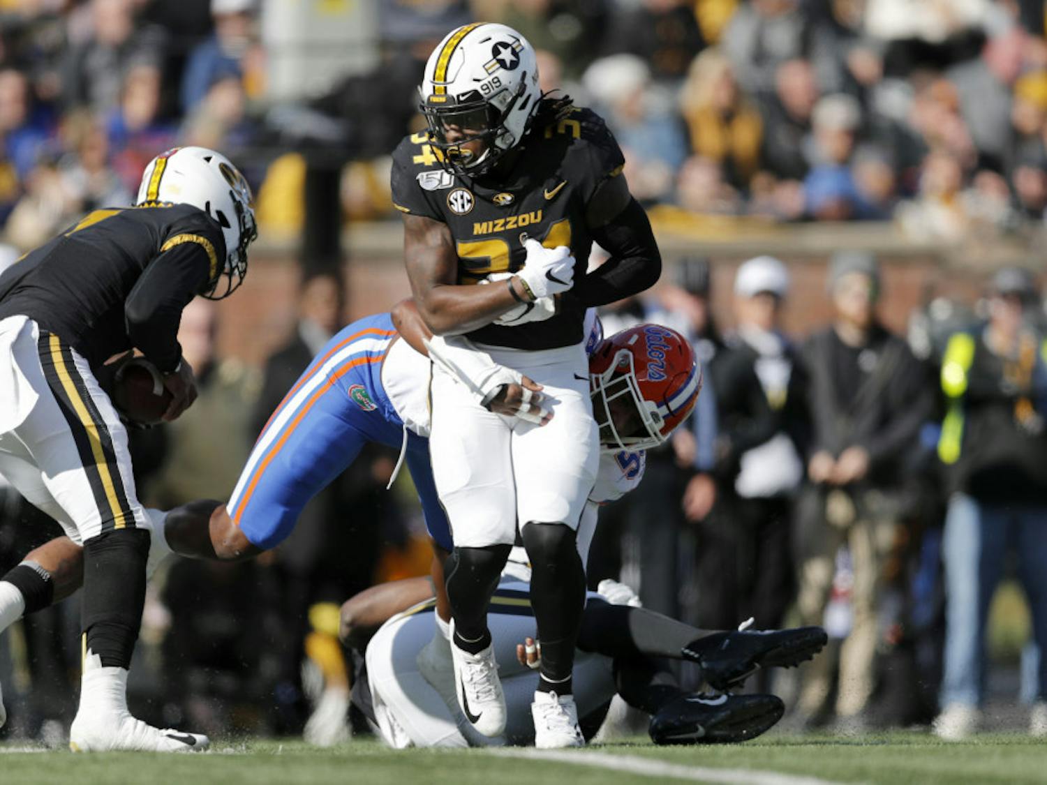 Missouri running back Larry Rountree III, front, struggles for yardage before being pulled down by Florida linebacker Jonathan Greenard during the first half of an NCAA college football game Saturday, Nov. 16, 2019, in Columbia, Mo. (AP Photo/Jeff Roberson)