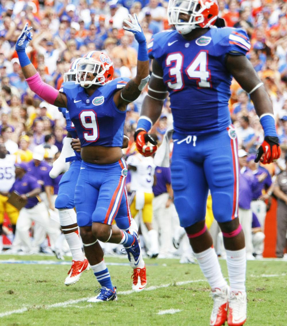 <p>Senior safety Josh Evans (9) and redshirt senior linebacker Lerentee McCray (34) celebrate after making a stop during Florida's 14-6 win against LSU on Oct. 6.</p>
