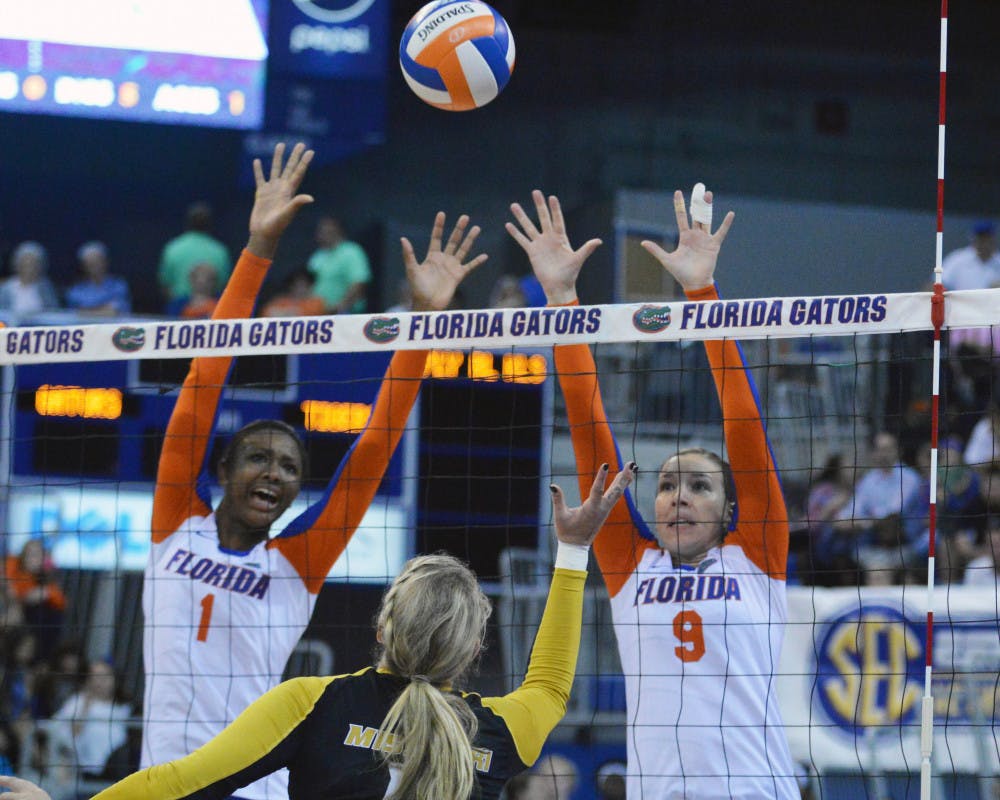 <p>Rhamat Alhassan (1) and Ziva Recek (9) attempt to block a kill attempt by a Missouri player during the Gators' 3-0 win against the Tigers in the O'Connell Center.</p>