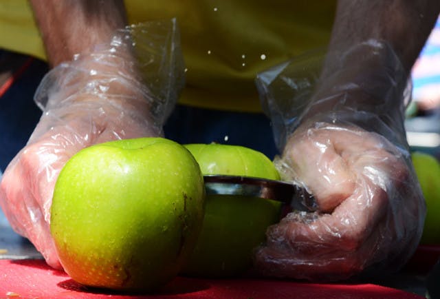 Richard Stehli, a veggie fest volunteer, uses an apple cutter and corer for granny smith apples during the VegFest at Plaza of the Americas in 2011.