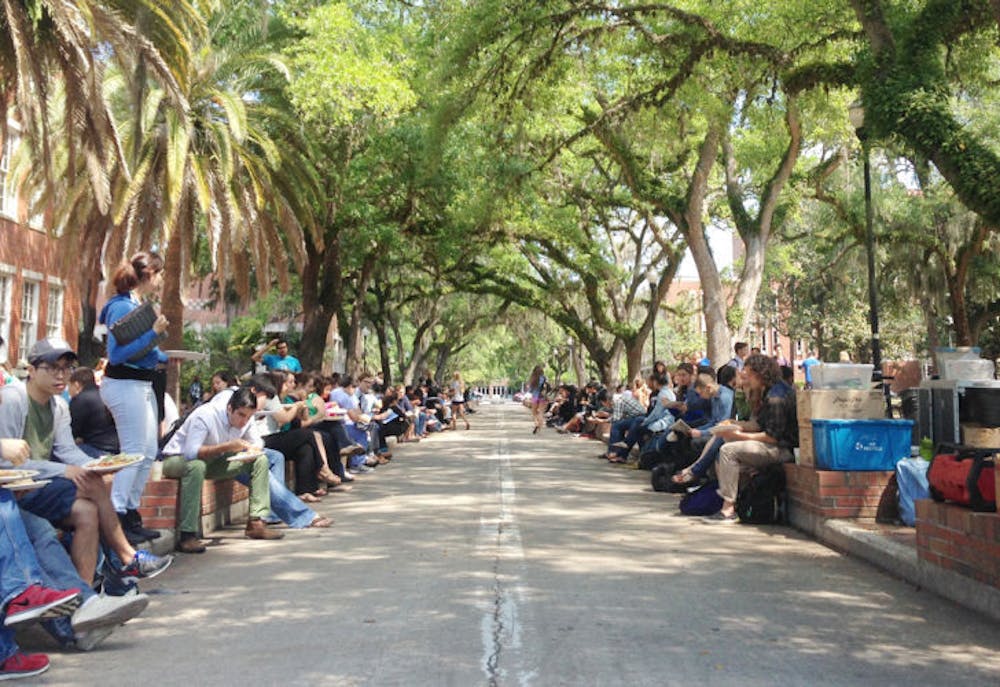<p class="p1"><span class="s1">UF students eat Krishna Lunch near the Plaza of the Americas. The warm weather and Wednesday menu offering of spaghetti brought a large turnout.&nbsp;</span></p>