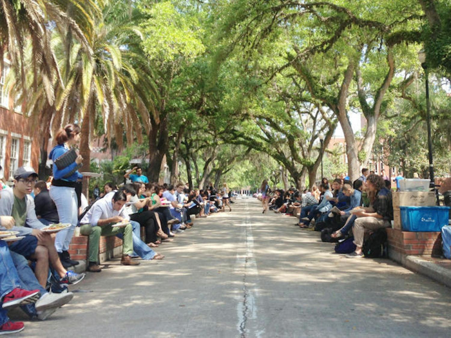 UF students eat Krishna Lunch near the Plaza of the Americas. The warm weather and Wednesday menu offering of spaghetti brought a large turnout. 
