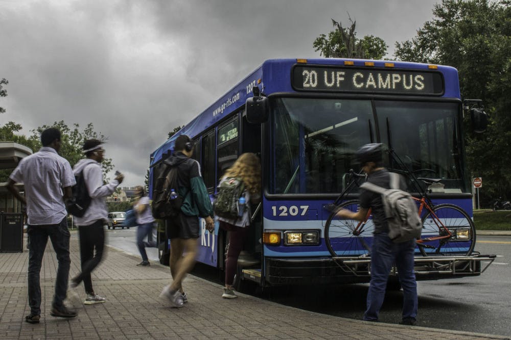 People board and exit an RTS bus Wednesday, July 24, 2019 by the The Hub at UF.