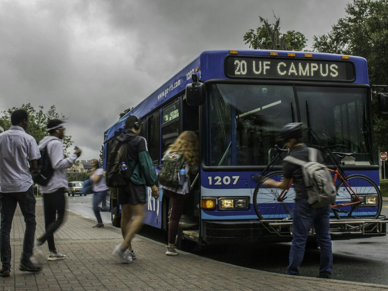 People board and exit an RTS bus Wednesday, July 24, 2019 by the The Hub at UF.