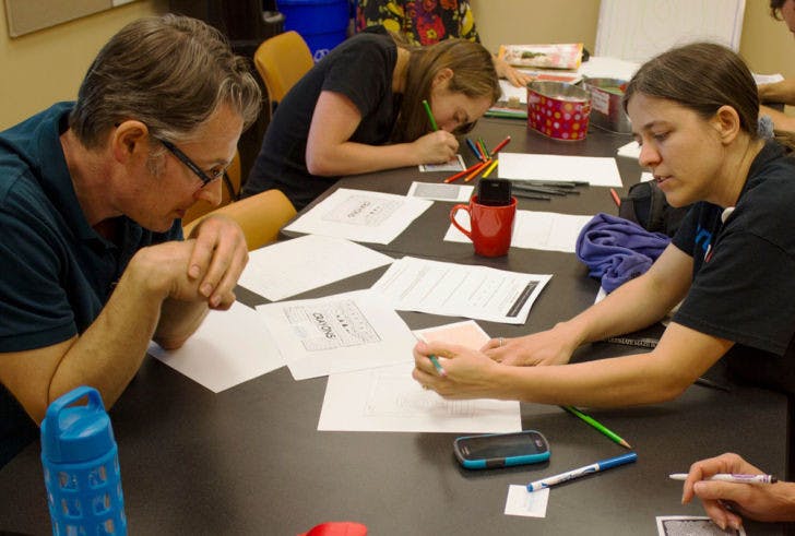 Sunita Canady, a 35-year-old artist in residence at UF Health Shands Hospital, gives Dylan Klempner, a 41-year-old writer in residence with the UF Health Arts in Medicine program, some tips on solving mazes as part of a creativity workshop at the UF Health Cancer Center on Tuesday.