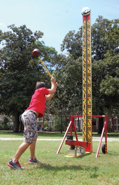 Computer engineering sophomore Reynaldo Calzadilla, 20, pummels the high striker hosted by UF Hillel on Tuesday on the Plaza of the Americas.