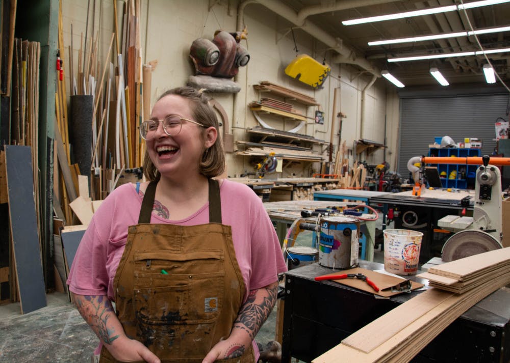 Samantha Lewis, a 24-year-old scene design master's student, in the set shop in the Nadine McGuire Theatre and Dance Pavilion.&nbsp;&nbsp;She designed the entire set herself out of all recyclable material for the play “Hills on Fire.”