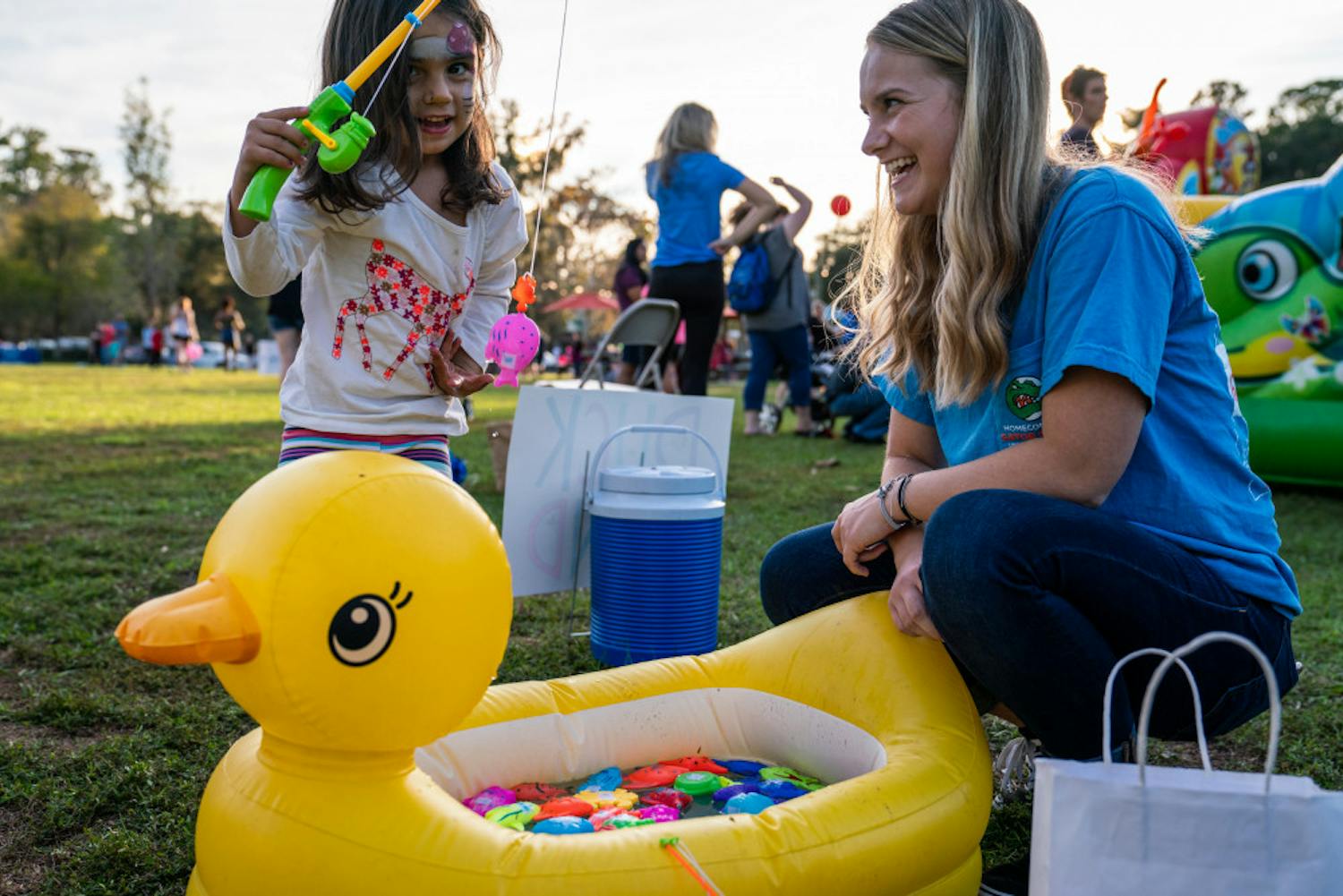 Volunteer Drew McCullough, 18, laughs as she watches a child fish for prizes during Sunday's “Hey, Neighbor!” carnival held at Magnolia Parke Square. McCullough, a UF sociology freshman, was recently diagnosed with Type 1 diabetes and received support from the UF Diabetes Institute's support group. The institute, along with UF's College Diabetes Network chapter, hosted the event to celebrate National Diabetes Awareness Month. 
