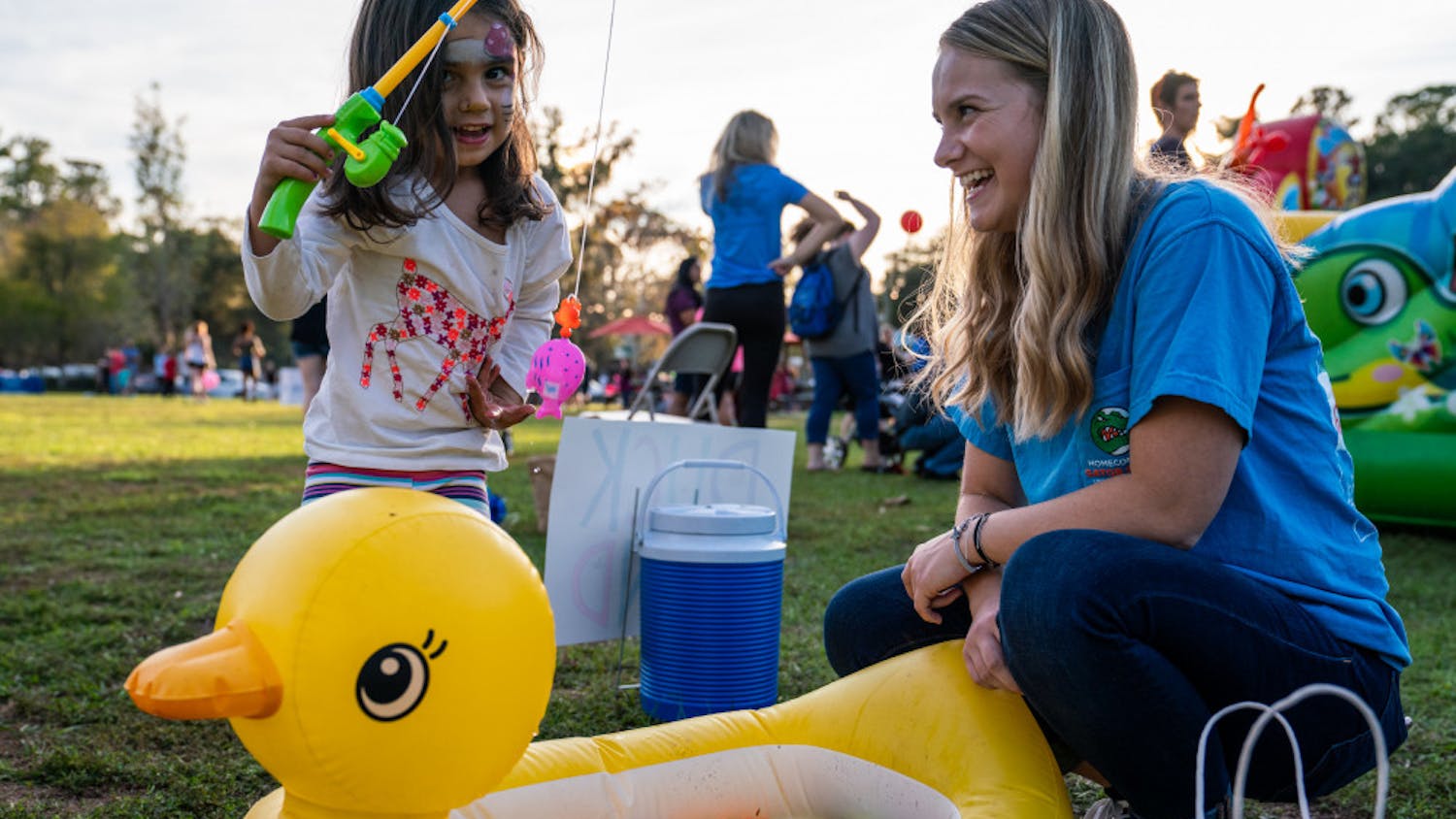 Volunteer Drew McCullough, 18, laughs as she watches a child fish for prizes during Sunday's “Hey, Neighbor!” carnival held at Magnolia Parke Square. McCullough, a UF sociology freshman, was recently diagnosed with Type 1 diabetes and received support from the UF Diabetes Institute's support group. The institute, along with UF's College Diabetes Network chapter, hosted the event to celebrate National Diabetes Awareness Month.