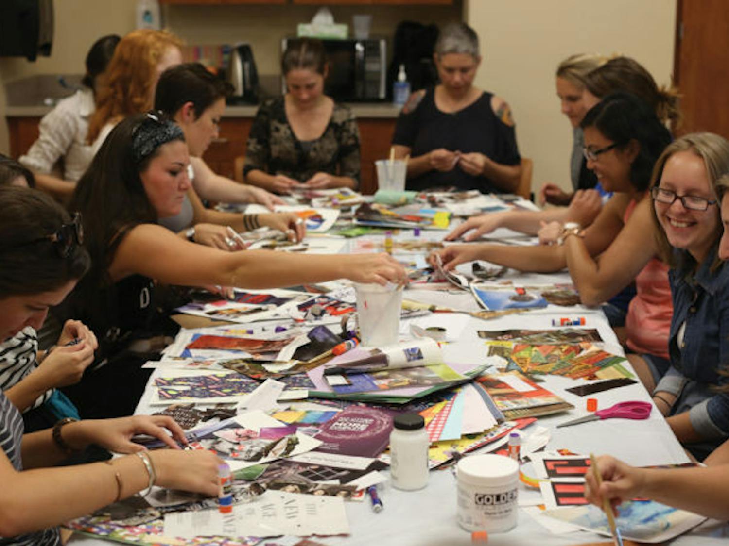 Attendees of the Shands Arts in Medicine Creative for Health workshop cut and paste magazine clips to make abstract collages.