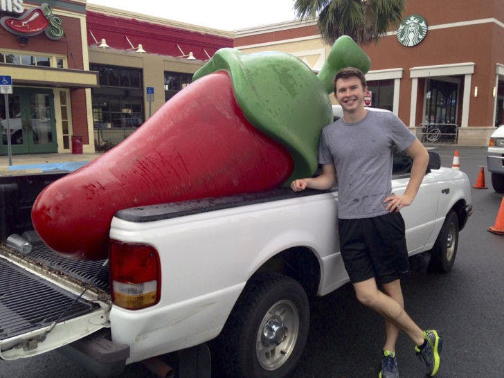 Daniel Helfrich, a 19-year-old UF classics junior, stands beside his newly bartered red pepper in the parking lot of Chili’s on Archer Road before it went missing.