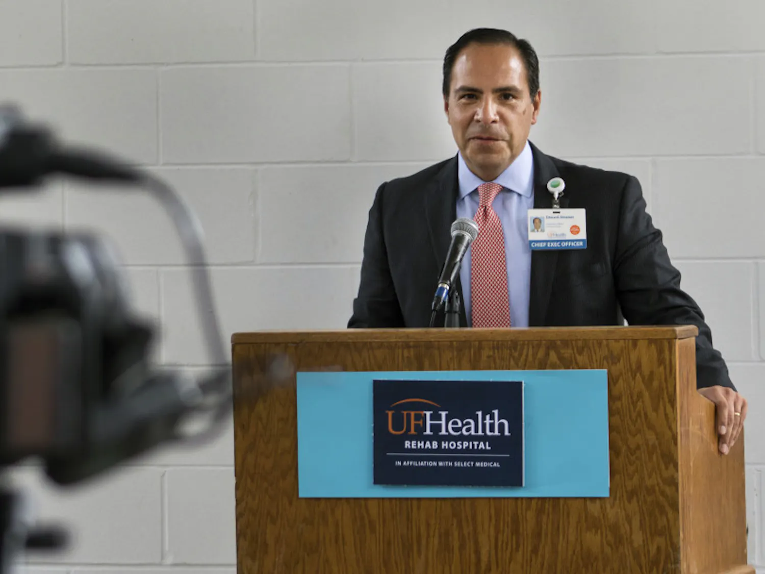 Edward Jimenez, the UF Health Shands chief executive officer, speaks Tuesday to an audience of about 50 people during a ribbon-cutting celebrating the upcoming opening of the UF Health Rehab Hospital. Jimenez was one of three speakers who made brief opening remarks before a rain shower cut the outdoor ceremony short. The new rehabilitation facility is located on 2708 SW Archer Road and is expected to begin admitting patients on Feb. 19.