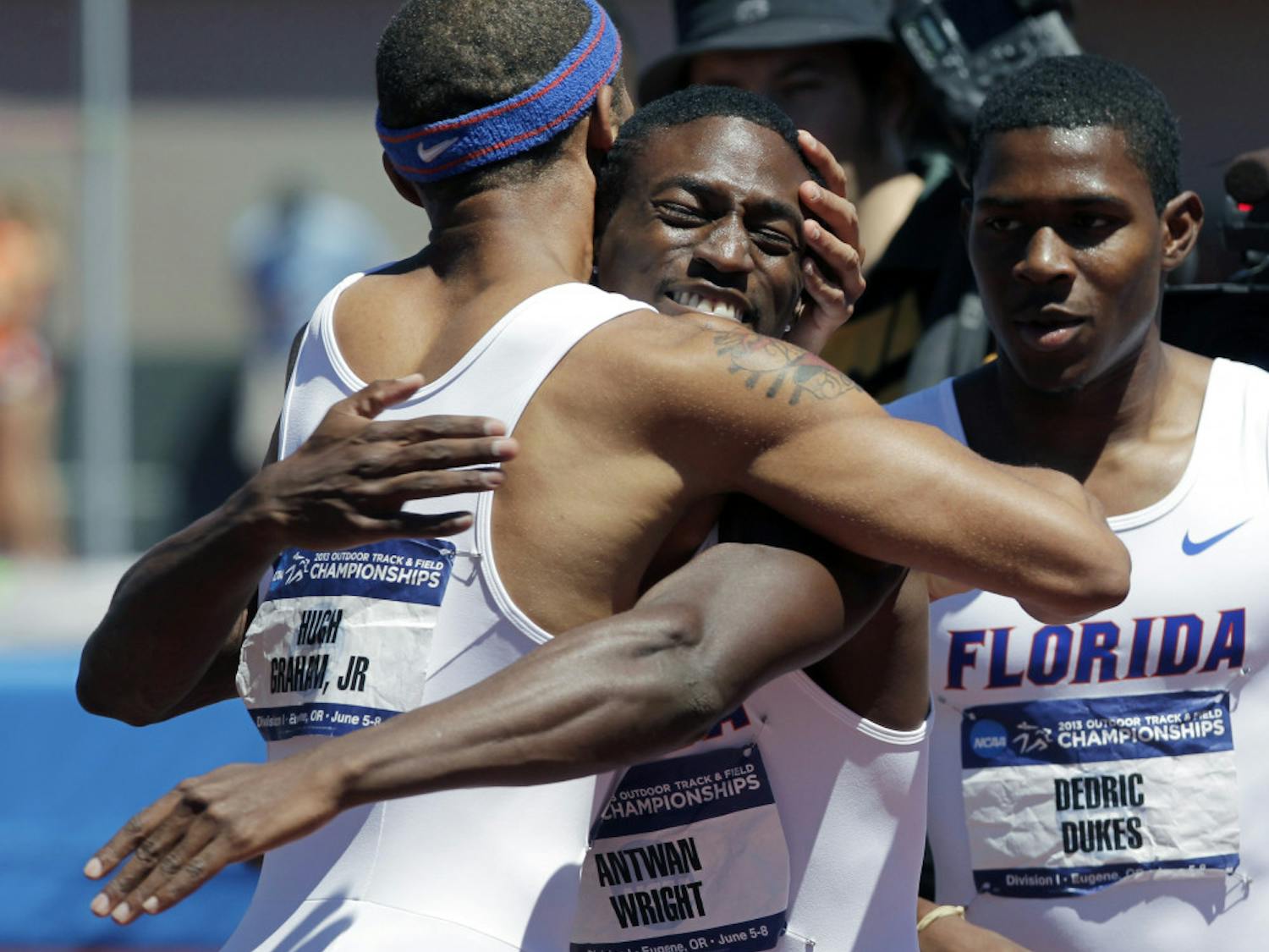 Florida's Hugh Graham Jr., left, hugs Antwan Wright as teammate Dedric Dukes looks on after winning the 4x400-meter race during the NCAA outdoor track and field championships in Eugene, Ore., Saturday, June 8, 2013. Florida tied with Texas A&M for the men's championship.