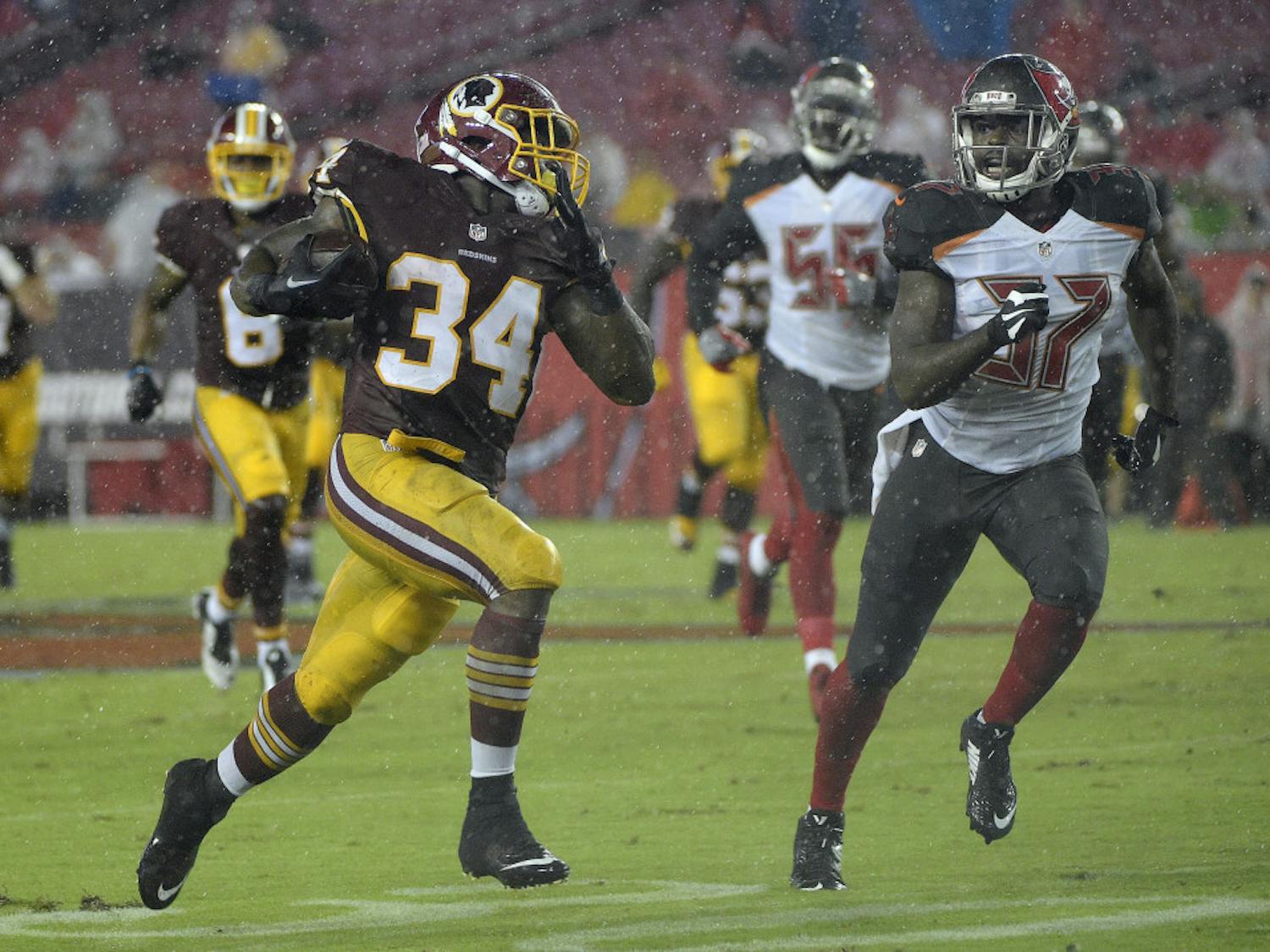 Washington Redskins running back Mack Brown (34) runs away from Tampa Bay Buccaneers strong safety Keith Tandy (37) on a 60-yard touchdown run during the second quarter of an NFL preseason football game Wednesday, Aug. 31, 2016, in Tampa, Fla. (AP Photo/Phelan M. Ebenhack)
