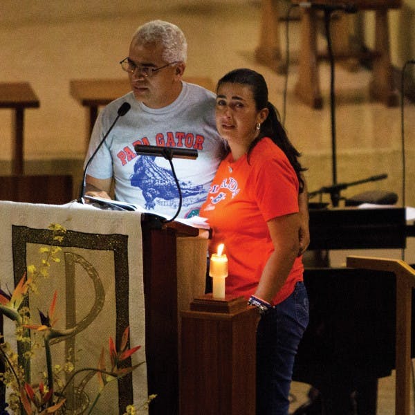 Carlos and Claudia Aguilar speak at St. Augustine Church on Monday night at a memorial for their son, Christian Aguilar, whose remains were discovered Friday.