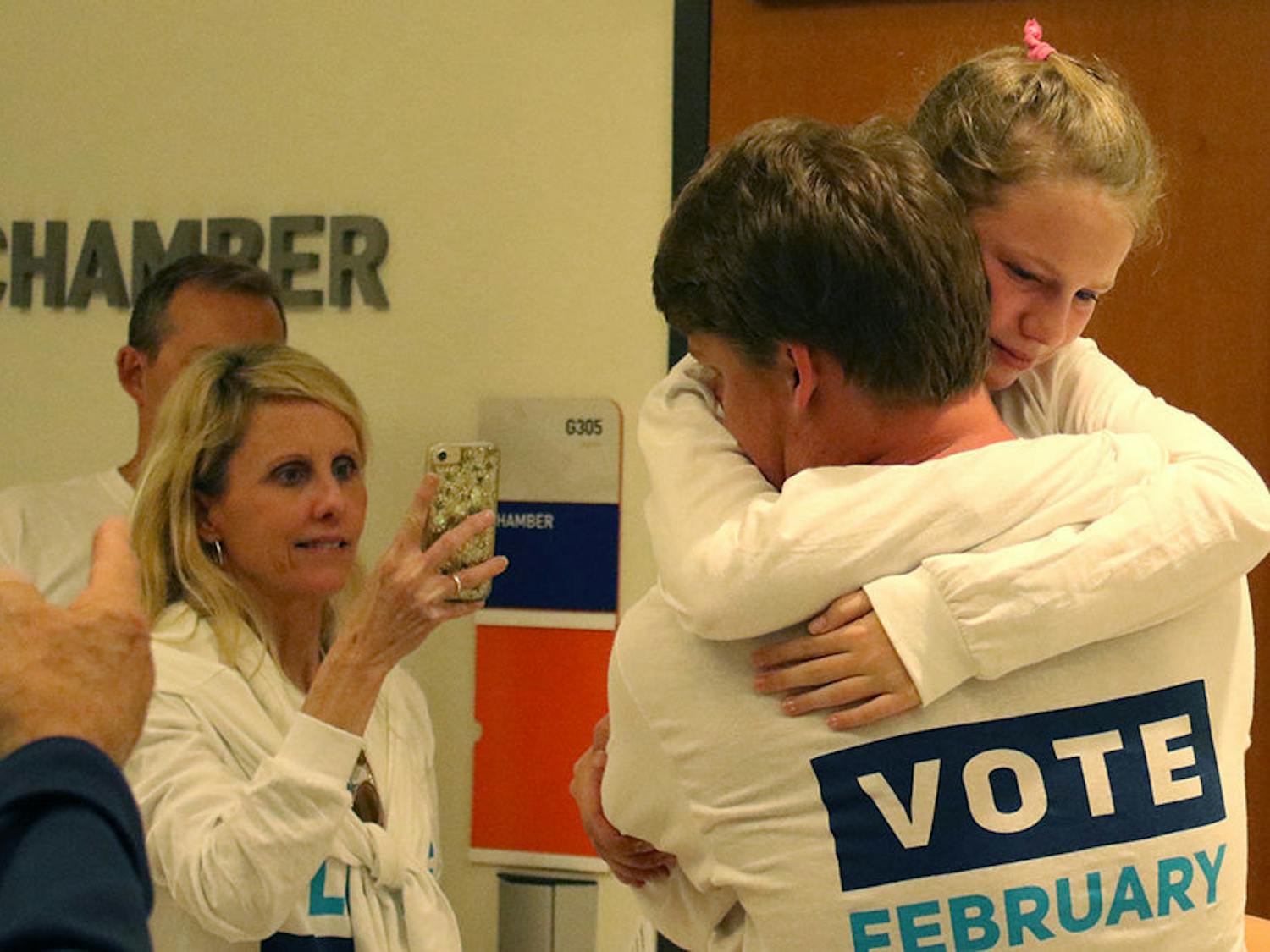 Michael Murphy, the 21-year-old Impact Party presidential candidate, embraces his younger sister Molly Murphy, 12, Wednesday night at the Reitz Union after winning UF Student Body president.