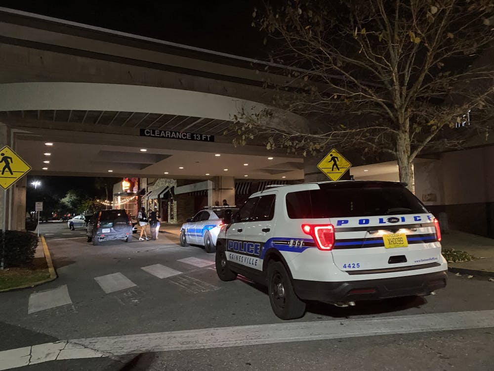 Law enforcement officers interview witnesses in front of Oaks Mall Thursday night after reports of a robbery in front of Pearle Vision, an eye care store located inside the mall. 