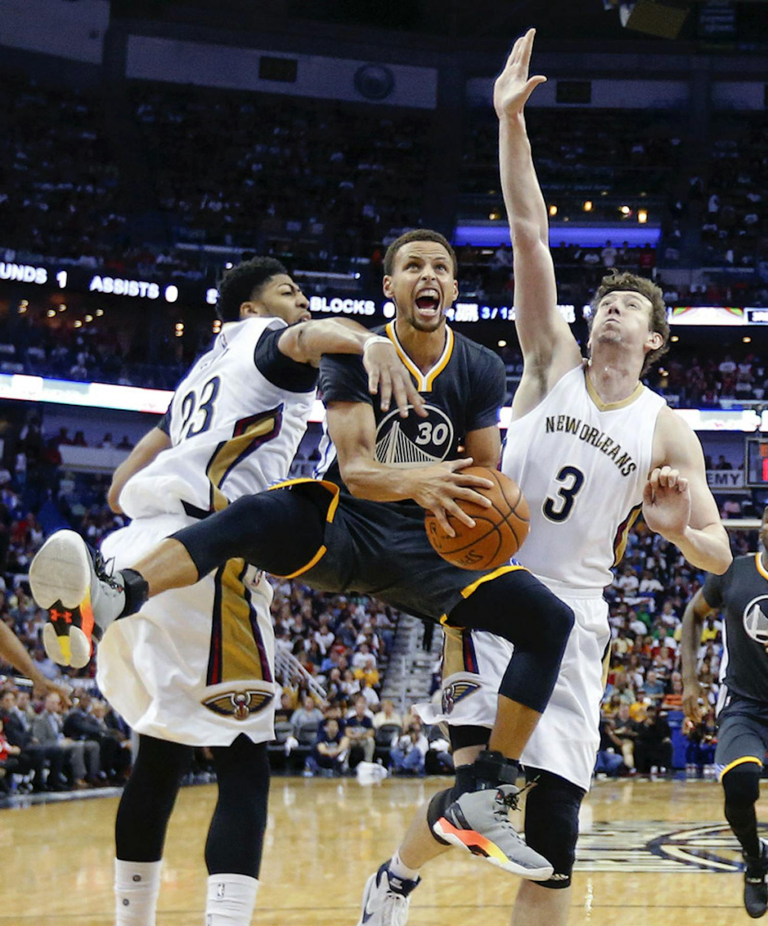 Golden State Warriors guard Stephen Curry (30) drives to the basket between New Orleans Pelicans forward Anthony Davis (23) and center Omer Asik (3) in the second half of an NBA basketball game in New Orleans, Saturday, Oct. 31, 2015. The Warriors won 134-120.