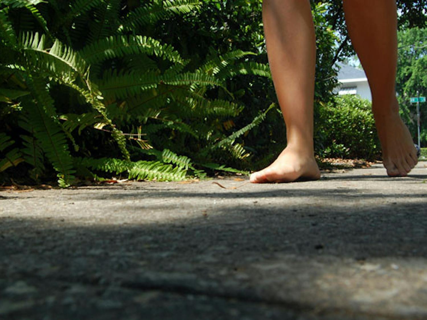 Kayla Malone, a 19-year-old freshman, walks around without shoes Tuesday. The political science major is partaking in the One Day Without Shoes campaign by TOMS Shoes to spread awareness on the impact a pair of shoes can have on children in poverty.