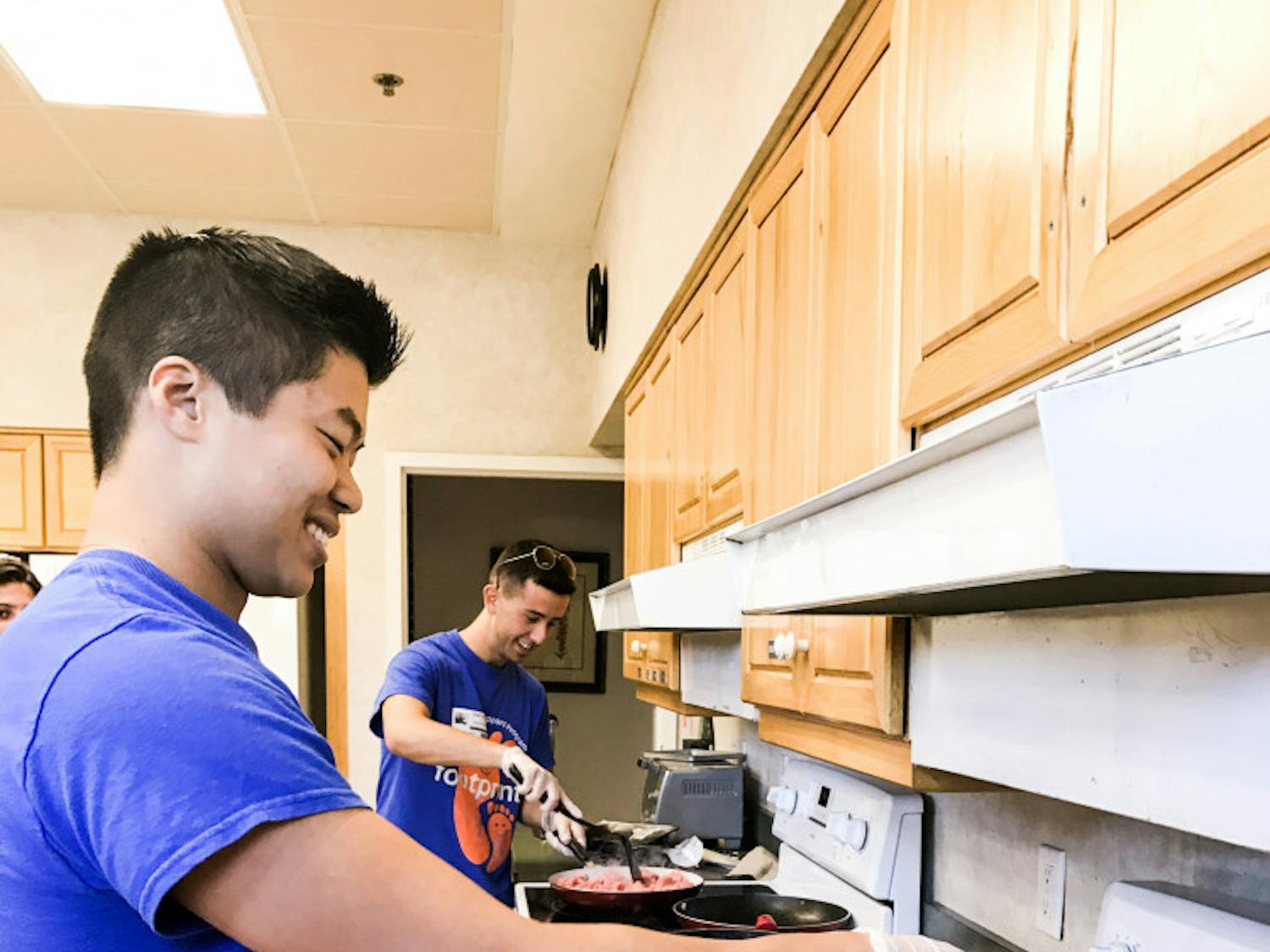 From left: Zachary Sandoval, a UF biology and psychology sophomore, cooks onions while Grant Filowitz, a UF graduate student, browns beef on a nearby stove at the Ronald McDonald House of Gainesville. The two Footprints Buddy and Support Program volunteers made sloppy joes for the families of the patients in Unit 42.
