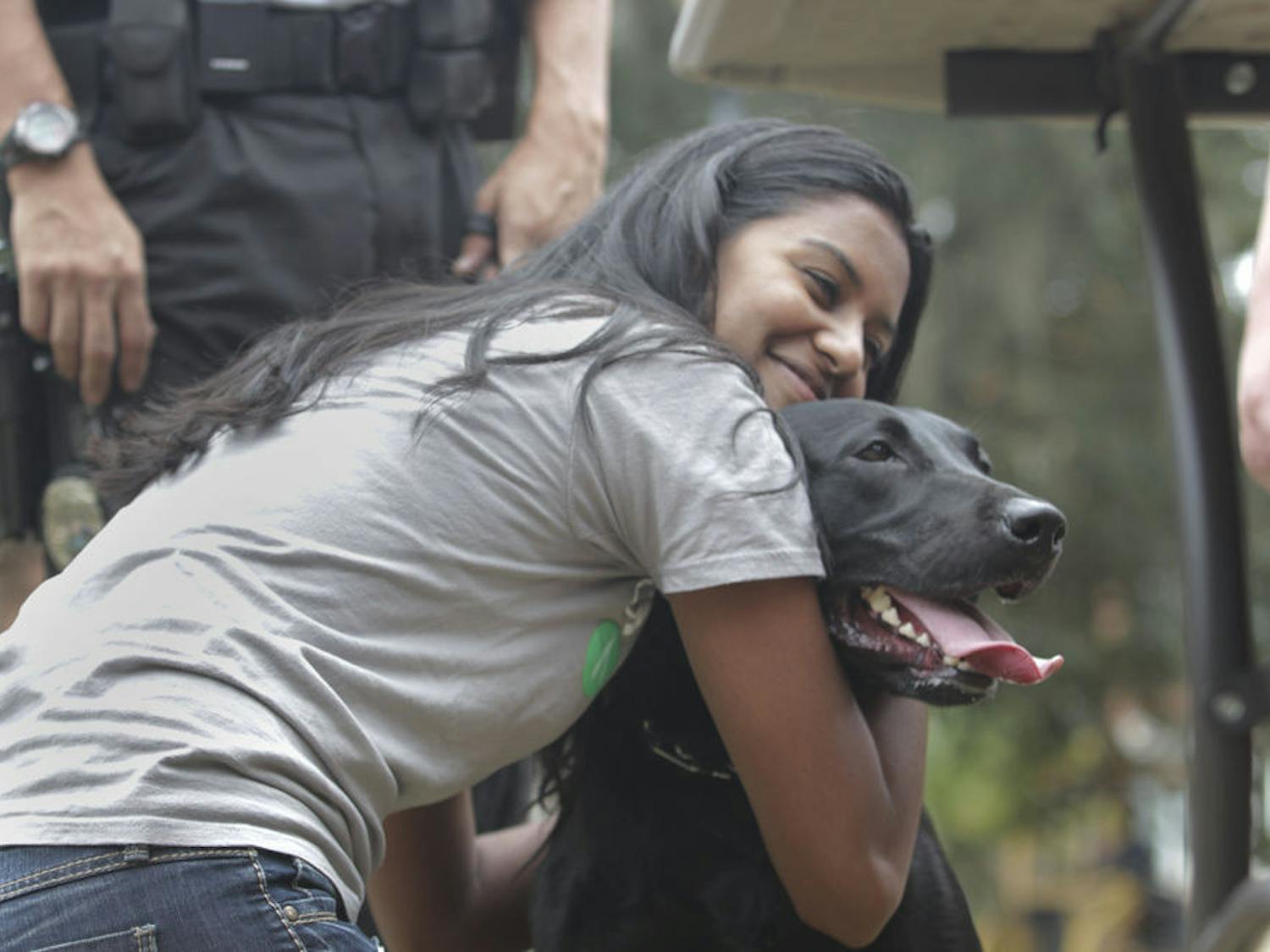 Leeashaa Ramoutar hugs Boomer, a 2 1/2-year-old black lab and UPD explosive detection K9 on Oct. 6, 2015. Officer Dale Holmes brought Boomer to Get FRUVED’s stress management event on the Plaza of the Americas.