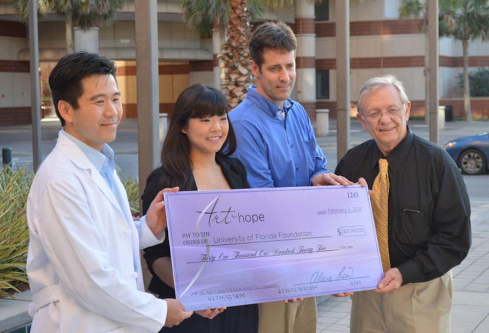 <p class="p1">Alicia Lew presents a check on Monday afternoon at the McKnight Brain Institute to Paul J. Reier, who said he wants to buy new equipment.</p>