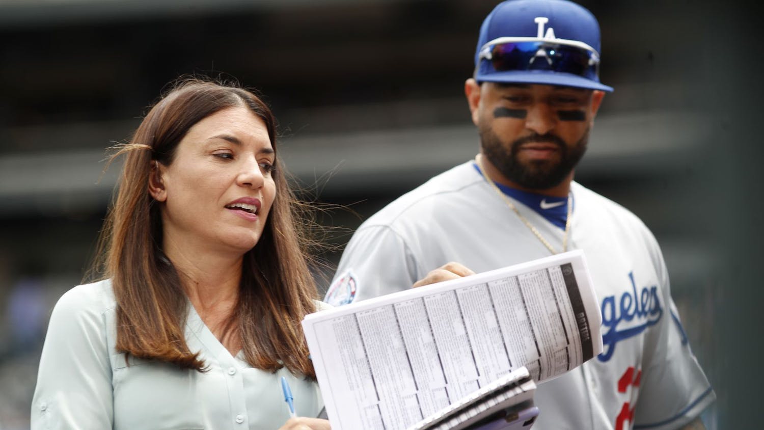 Alanna Rizzo, left, delivers a report before a 2018 game between the Los Angeles Dodgers and Colorado Rockies in Denver as then-Dodgers left fielder Matt Kemp looks on. Rizzo on Tuesday night will be part of Major League Baseball’s first all-female broadcasting crew. [ DAVID ZALUBOWSKI | AP ]