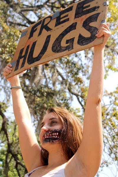 Eighteen-year-old animal biology freshman Megan Smith, dressed as a zombie, offers "free hugs" to passersby in Turlington on Tuesday to promote the Humans vs. Zombies game.
