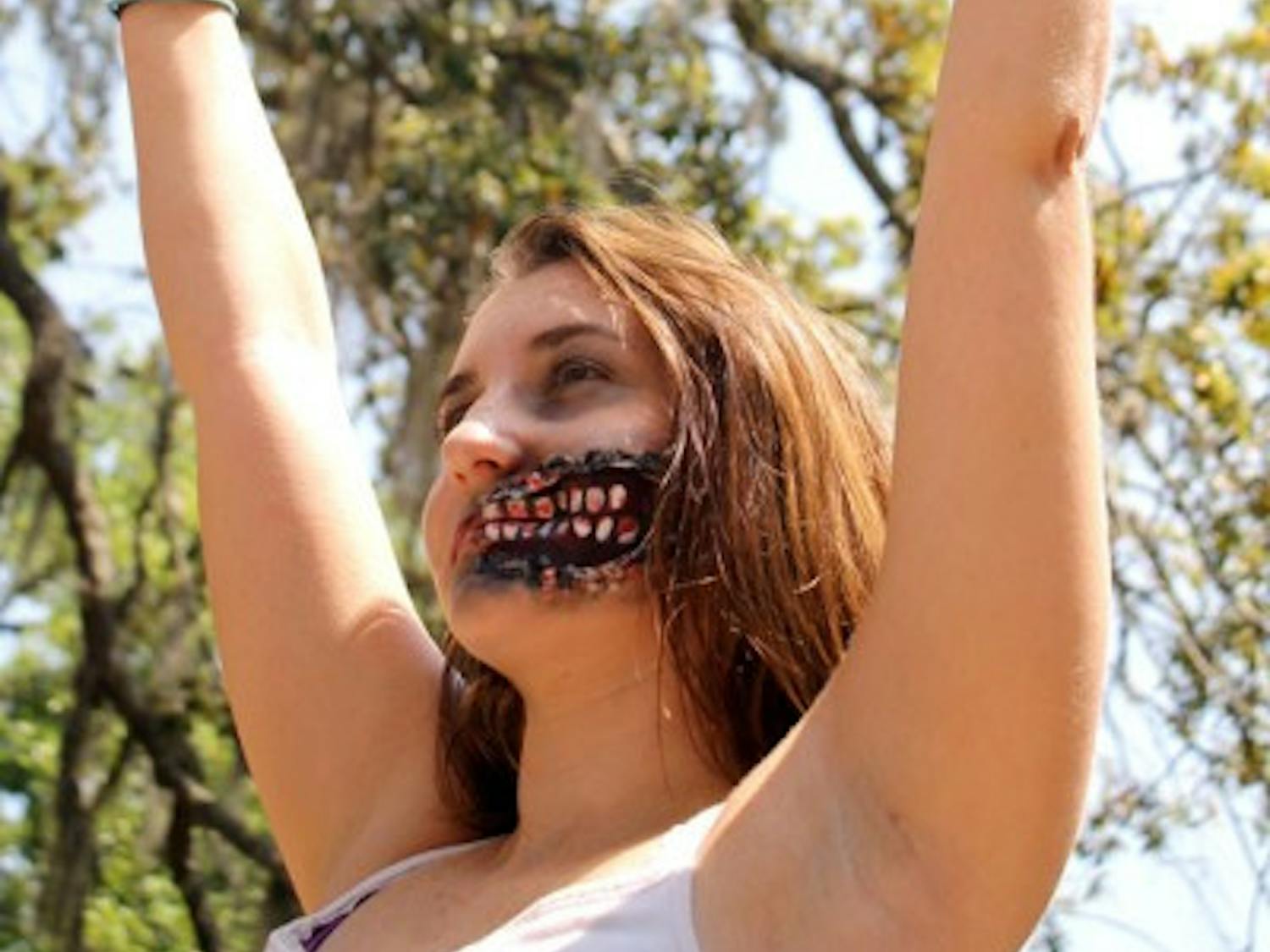 Eighteen-year-old animal biology freshman Megan Smith, dressed as a zombie, offers "free hugs" to passersby in Turlington on Tuesday to promote the Humans vs. Zombies game.