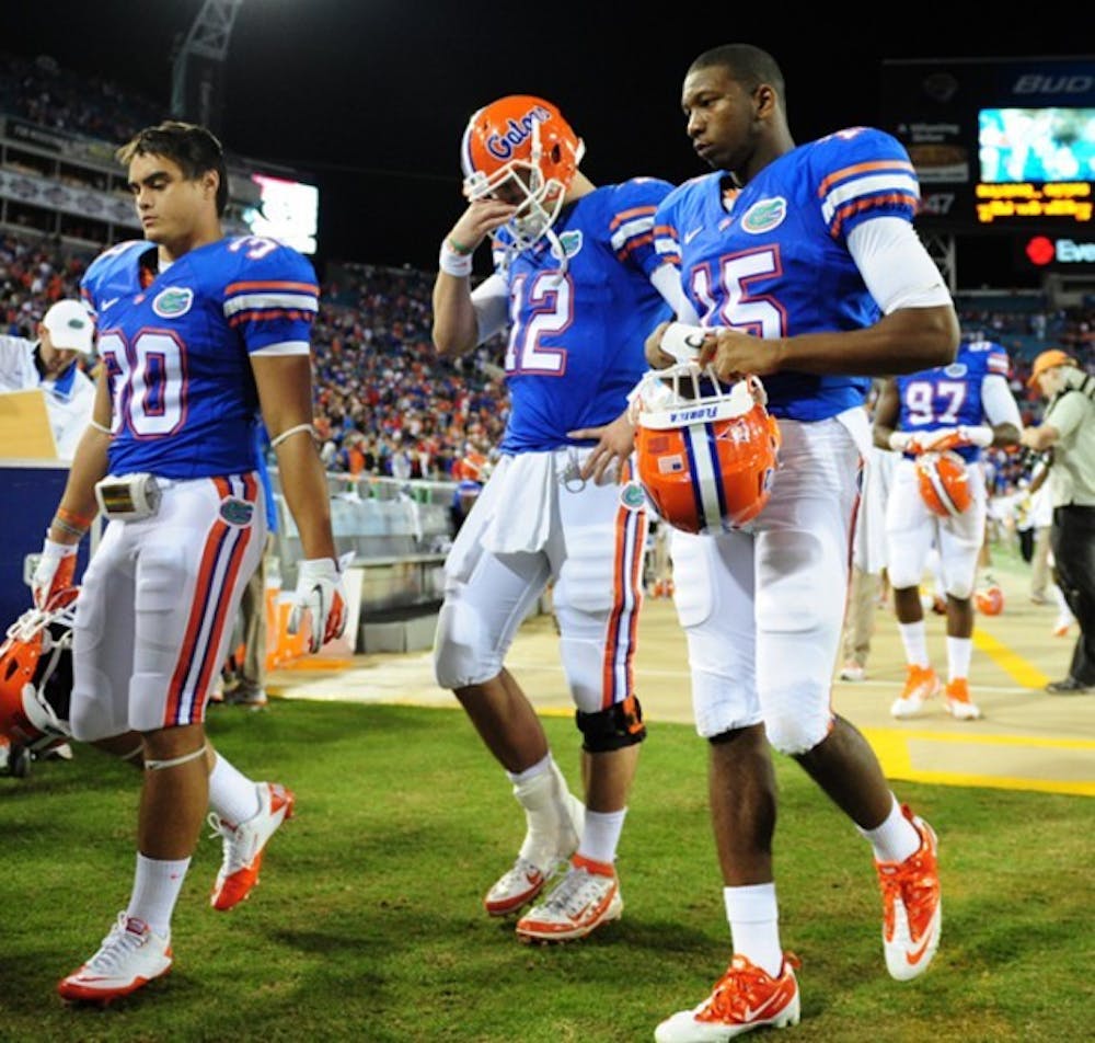 <p>Florida quarterback John Brantley (12), safety Tim Clark (30) and cornerback Louchiez Purifoy (15) walk off the field in Jacksonville after losing 24-20 to Georgia. It was UF’s fourth straight loss in October.</p>