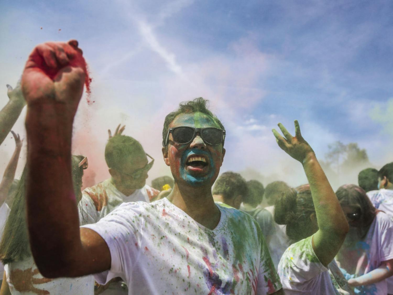Khem B. Banjara, a 30-year-old neuro technologist at UF Health Shands Cancer Hospital, throws paint during the UF Holi Festival of Colors, organized by the UF Indian Student Association and Student Government, on Sunday afternoon. Above, more than 1,000 people attended the event, which lasted more than three hours.