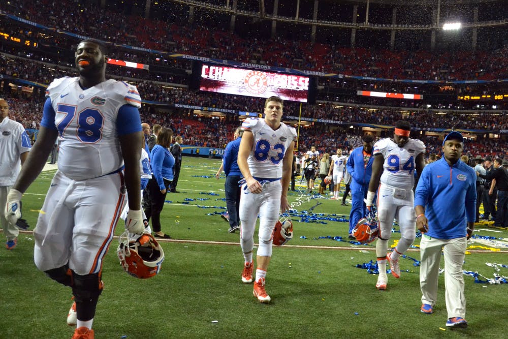 <p>UF's David Sharpe (78), Jake McGee (83) and Bryan Cox (94) walk off the field at the Georgia Dome following Florida's 29-15 loss to Alabama in the SEC Championship Game on Dec. 5, 2015, in Atlanta.</p>