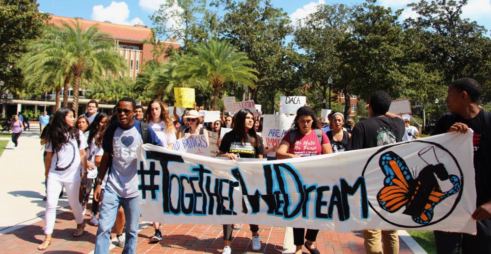 Protesters chant, “Dreamers united will never be defeated,” on their way to the Reitz Union to stand in solidarity to show support for Deferred Action for Childhood Arrivals program students.