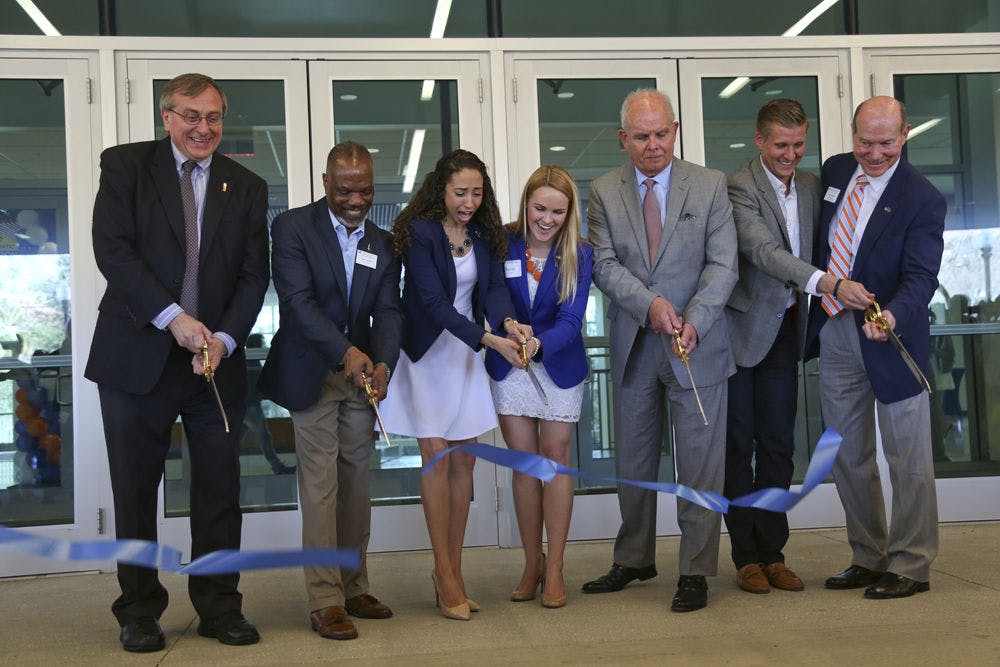 <p>From left, UF President Fuchs, Reitz Union Executive Director Eddie Daniels, Student Body President Joselin Padron-Rasines, student advisory committee for the Reitz expansion project member Sarah Frick, Former UF President Bernie Machen, Former Student Body President Jordan Johnson and Vice President for Student Affairs Dave Kratzer cut the ceremonial ribbon at the grand reopening of the Reitz Union on Saturday.</p>