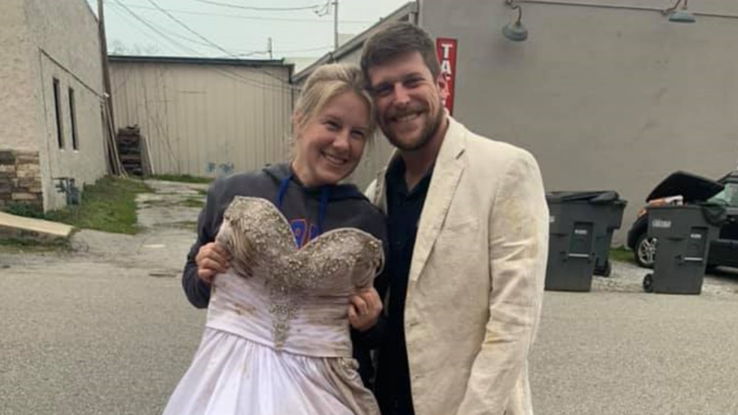 Lauren Hampton Farmer, 31, holds her wedding dress that was found after tornadoes in Cookeville, Tennessee destroyed her house and spread out her belongings in early March. Her husband, Kory Farmer, is wearing his wedding blazer that was also found in the aftermath, alongside her UF diploma. She graduated from UF in 2010.