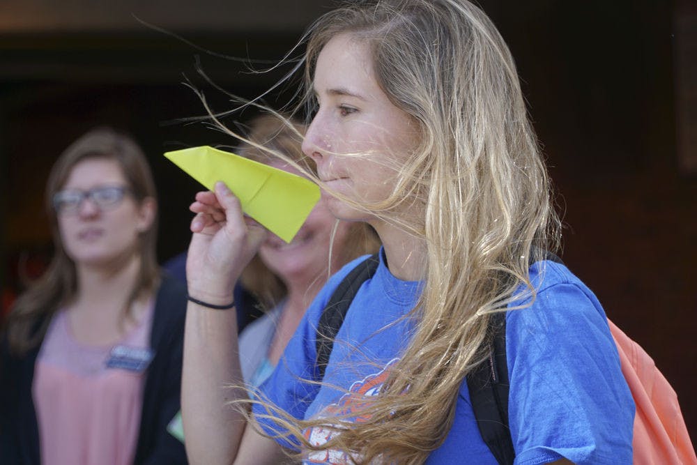 Mariana Franz, a 20-year-old UF applied physiology and kinesiology junior, tosses her paper airplane outside Ben Hill Griffin Stadium on Oct. 20, 2015. The College of Journalism and Communications and the College of Health and Human Performance held a paper airplane competition to raise money for the UF Campaign for Charities.