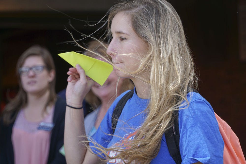 <p>Mariana Franz, a 20-year-old UF applied physiology and kinesiology junior, tosses her paper airplane outside Ben Hill Griffin Stadium on Oct. 20, 2015. The College of Journalism and Communications and the College of Health and Human Performance held a paper airplane competition to raise money for the UF Campaign for Charities.</p>